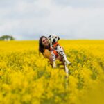 Lorren & Loki The Dalmatian @polka_dot_loki on Instagram if you use this image for artwork please tag me id love to see it, a woman holding a dalmatian dog in a field of yellow flowers